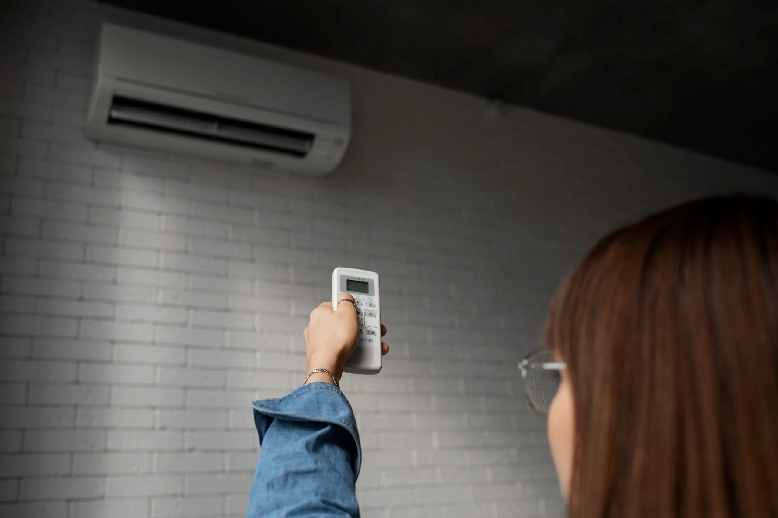 Mujer controlando la climatización de su casa desde el panel